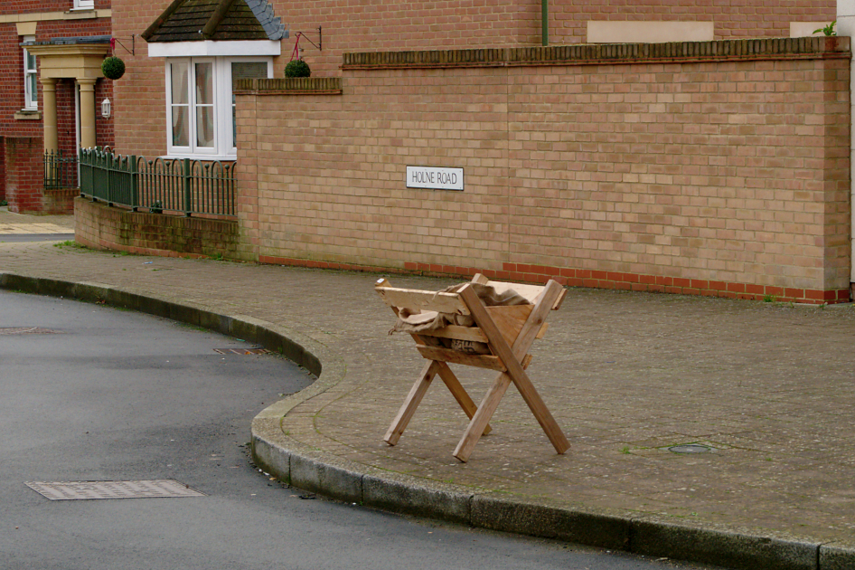 Wood manger at a pavement edge.